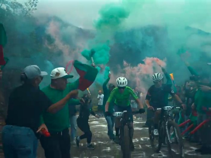 Hinchas con banderas y humo verde reciben a los ciclistas · Ibiza Eventos