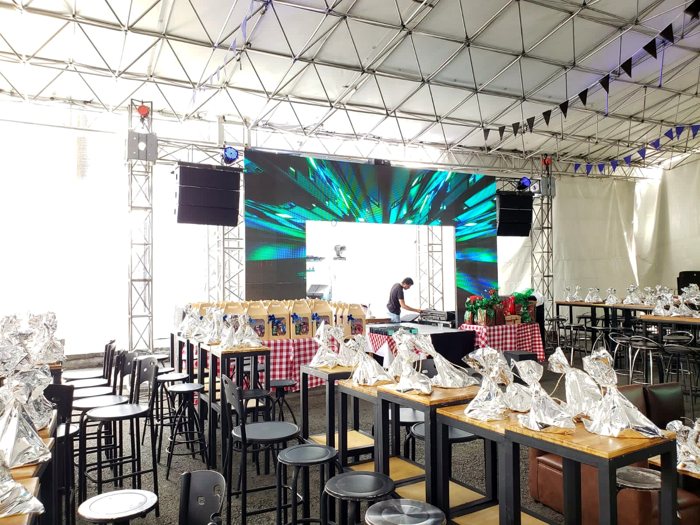 Mesas y tarima con pantalla LED para una fiesta de fin de año empresarial · Ibiza Eventos