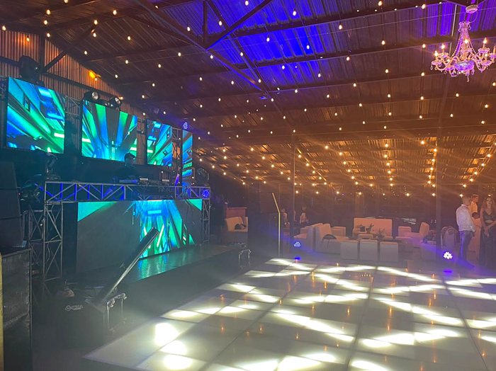 Salón con luces colgantes, pista LED y cabina de DJ con pantallas · Ibiza Eventos